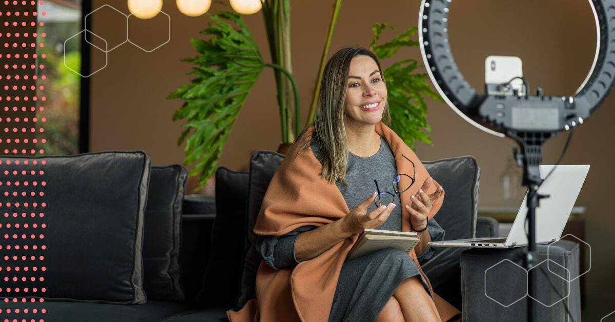 Woman on couch, speaking to her phone in a ring light.