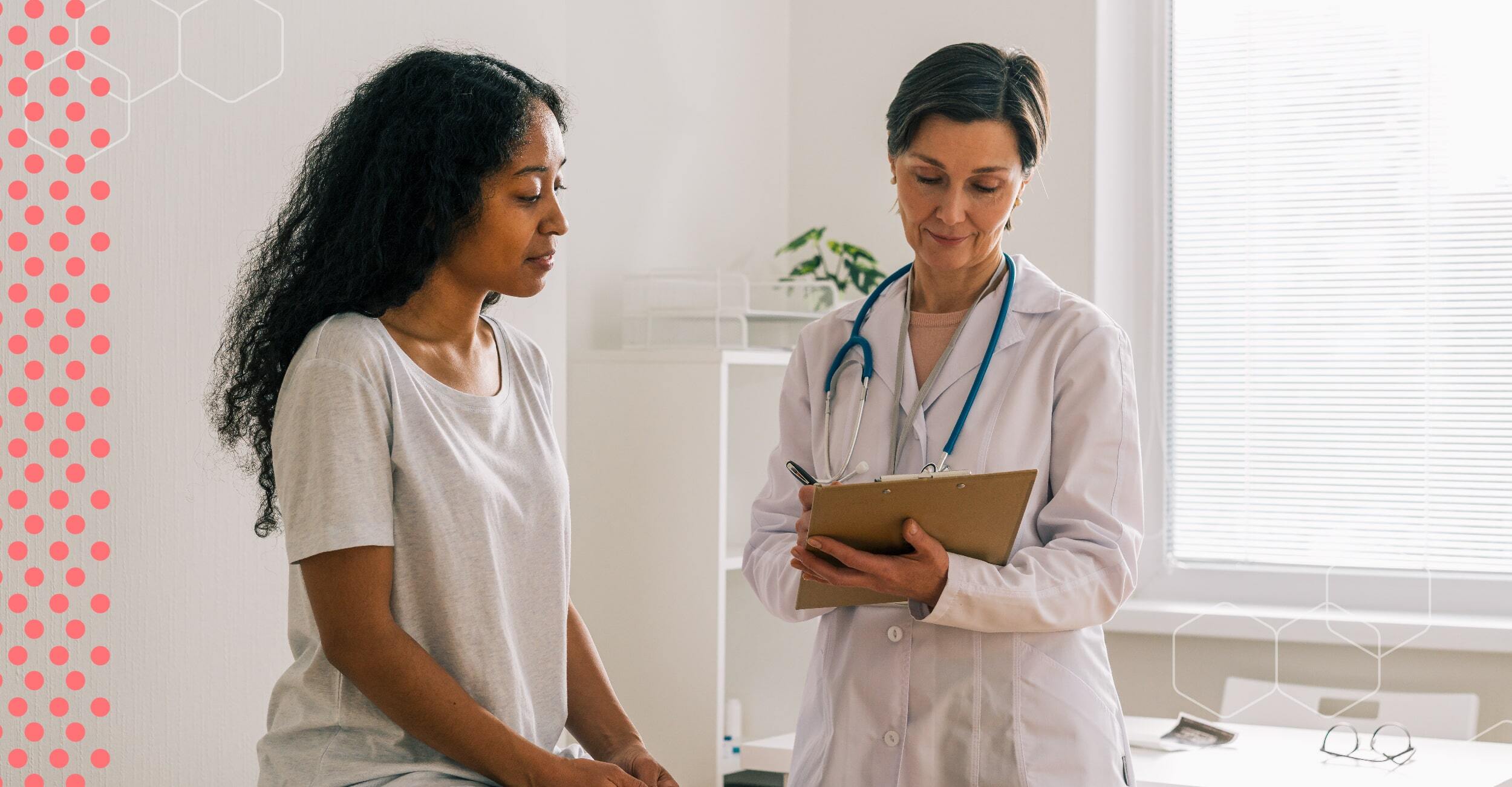 A woman sits in a doctor's office with a doctor, holding a clipboard.