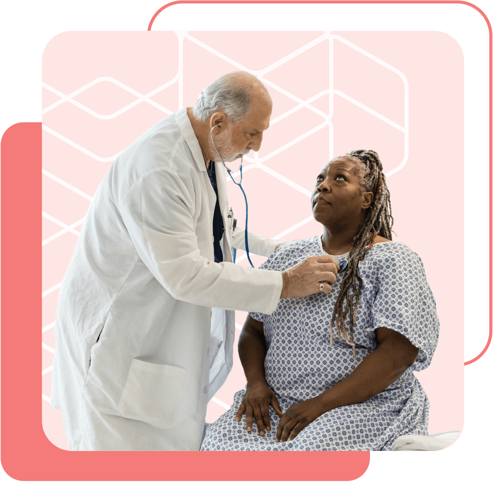 A senior white doctor uses a stethoscope to listen to a Black patient's heart.