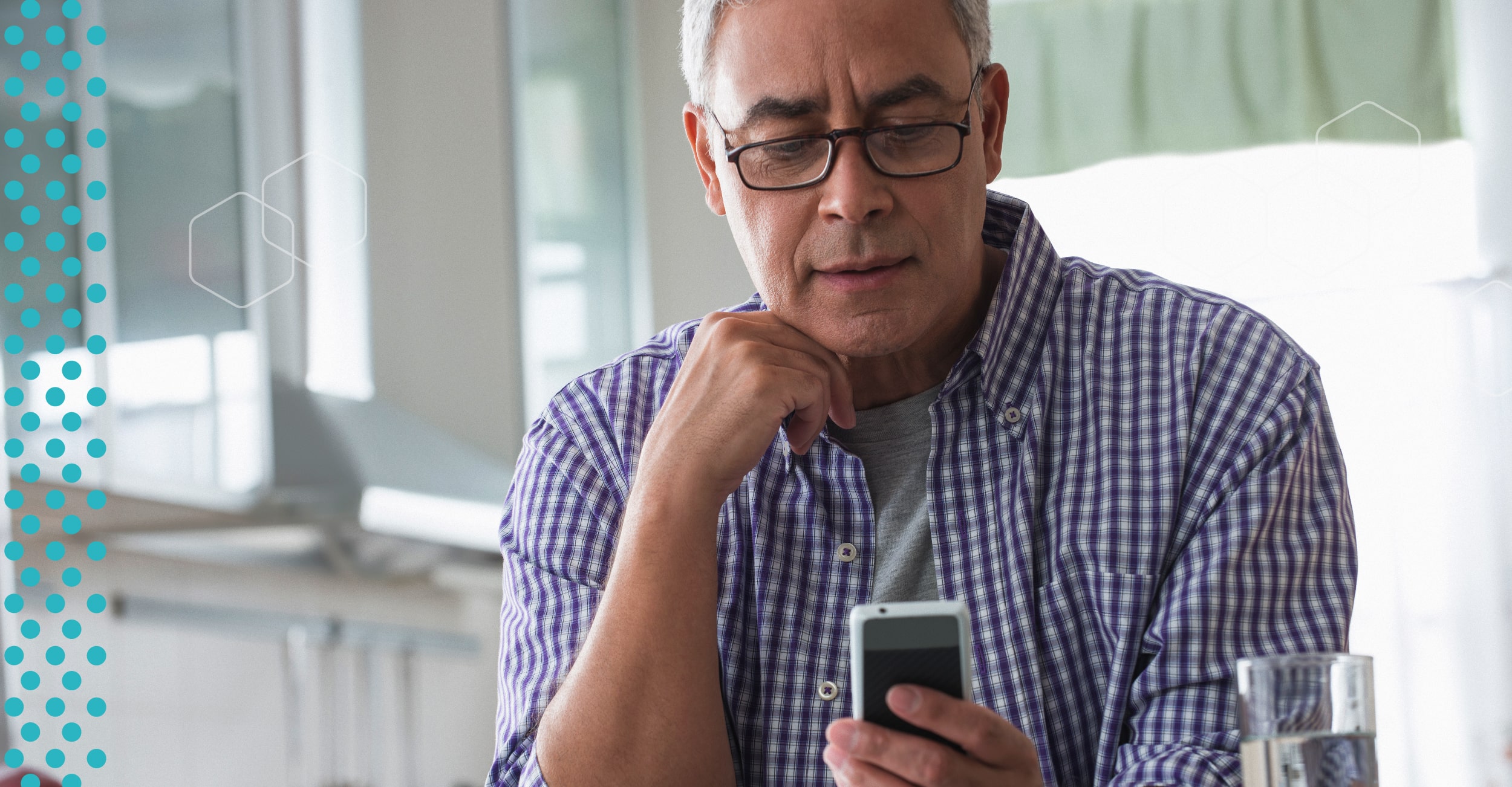 An elderly man looking at his phone.