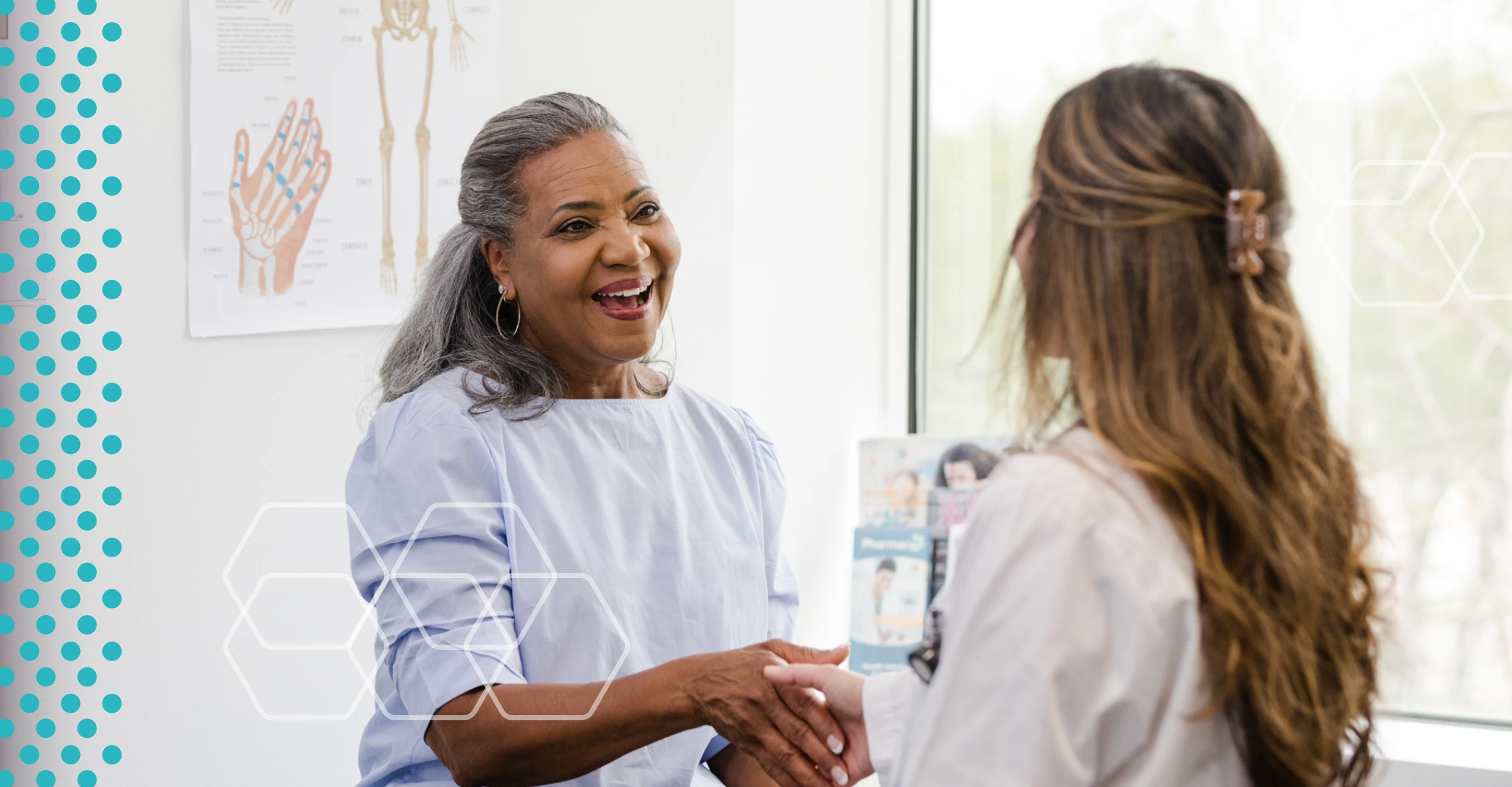 An elderly woman patient shakes hands with her doctor.