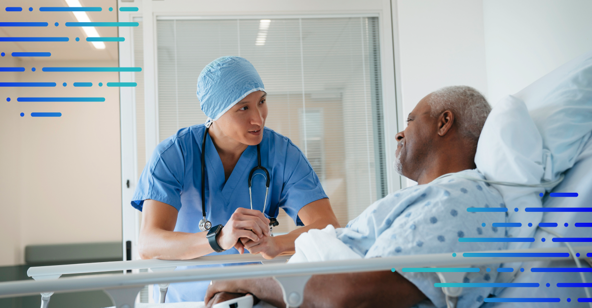 A doctor talks with a patient who is lying in a hospital bed.